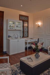 a living room with a table with a vase of flowers at Parc Royale Suites Hotel in Cuenca