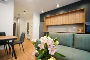 a living room with a couch and a table with flowers at ToRo Hospitality in Mostar