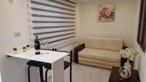 een kleine woonkamer met een witte tafel en een stoel bij Suite Numa in Cuenca +7 foto's