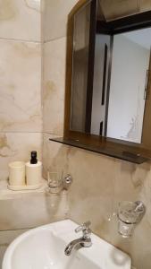 een badkamer met een wastafel en een spiegel bij Suite Numa in Cuenca