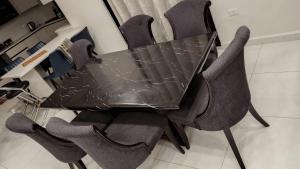 a black table with four chairs with a glass table at شقة جميلة in Irbid +6 photos