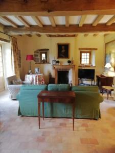 - un salon avec un canapé vert et une cheminée dans l'établissement charmante longère sur domaine de Kerguéréon, à Ploubezre