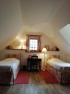 Ce lit se trouve dans un dortoir doté d'un bureau et d'une fenêtre. dans l'établissement charmante longère sur domaine de Kerguéréon, à Ploubezre