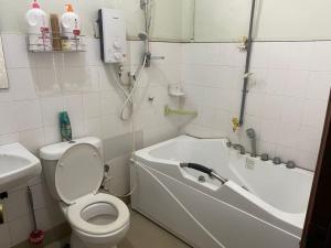 Un baño con inodoro, bañera y lavabo. en Comfortable Retreat in Megah Ria, en Masai