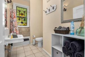 a bathroom with a sink and a toilet and a mirror at Historic Birmingham 4 BR 3 Bath in Birmingham +72 photos