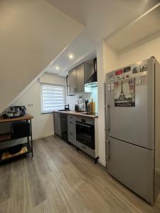 a kitchen with a stainless steel refrigerator and a counter at City Lounge Bielefeld 004 in Bielefeld +7 photos