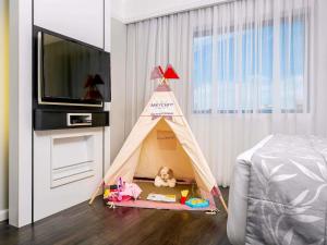 a toy teepee tent in a bedroom with a tv at Mercure São Paulo Ibirapuera Privilege in Sao Paulo