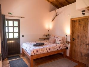 een slaapkamer met een bed en een houten deur bij Casa Flor - Flower home in Fajazinha