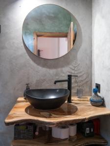 een badkamer met een zwarte wastafel en een spiegel bij Casa Flor - Flower home in Fajazinha +21 foto's