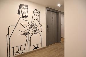 a drawing of two people sitting on chairs in a hallway at Super Townhouse All In One in kolkata