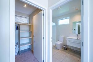 ein Badezimmer mit Toilette, Waschbecken und Spiegel in der Unterkunft Wanaka Haven Spa Views and fantastic outdoor living in Wanaka + 31 Fotos