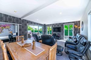 ein Wohnzimmer mit einem Holztisch und Stühlen in der Unterkunft Wanaka Haven Spa Views and fantastic outdoor living in Wanaka