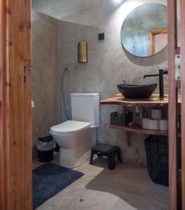 een badkamer met een wit toilet en een wastafel bij Casa Flor - Flower home in Fajazinha