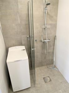 a shower with a glass door next to a toilet at Central Studio for 2 in Lahti +10 photos