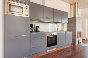 een keuken met roestvrijstalen kasten en een magnetron bij Spacious Apartment for 6 with Sauna in Harviala +6 foto's