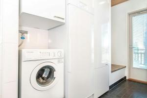 een witte wasruimte met een wasmachine en droger bij Spacious Apartment for 6 with Sauna in Harviala