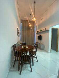 una sala da pranzo con tavolo e sedie in legno di Eni · New Intermares a Ilha da Restinga