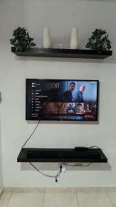 a flat screen tv hanging on a white wall at Apartamento palmera del este 3 in La Javilla