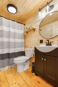 a bathroom with a toilet and a sink and a mirror at Sunrise Sanctuary -Modern Yurt in Brookville