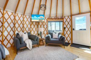 a living room with two chairs and a door at Adventure Abode - Modern Yurt in Brookville
