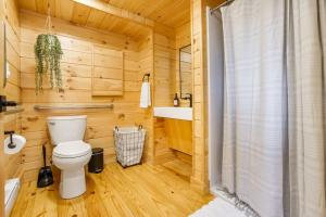 a wooden bathroom with a toilet and a sink at Adventure Abode - Modern Yurt in Brookville