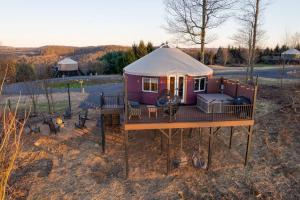 a small purple house with a deck and a grill at Starlit Haven - Modern Yurt in Brookville +12 photos