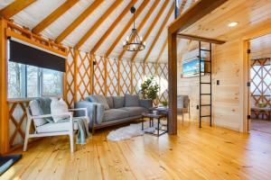 a living room with a couch and a table at Starlit Haven - Modern Yurt in Brookville