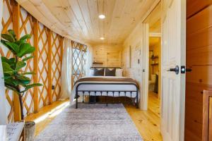a bedroom with a bed in a room with wooden walls at Starlit Haven - Modern Yurt in Brookville