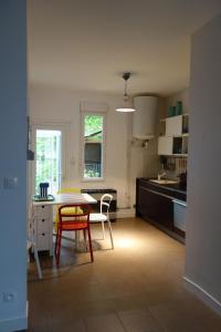 cocina con mesa y sillas en una habitación en La Garzette en La Riche