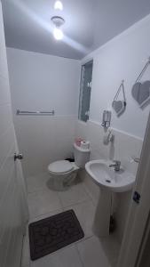 a white bathroom with a toilet and a sink at Apartamento palmera del este 3 in La Javilla +29 photos