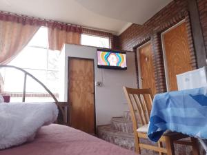 a bedroom with a tv on the wall and a bed at Complejo Turístico Hugo Ávila in La Rioja