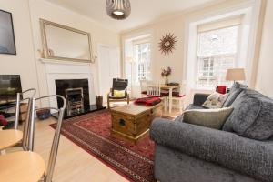 a living room with a couch and a table at Luxury New Town 1 Bed Apartment in Edinburgh