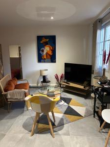 a living room with a table and a tv at Grand studio refait à neuf in Vierzon