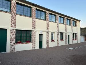 a large brick building with windows on a street at Grand studio refait à neuf in Vierzon