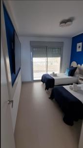 a bedroom with two beds and a flat screen tv at Best Stupa Hills JM, magnífico apartamento y vistas in Benalmádena