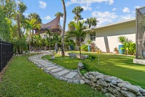 una casa con un patio con un camino de piedra en Islandy, en Sanibel