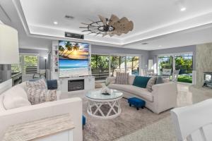 Una sala de estar con un sofá y un televisor. en Islandy, en Sanibel