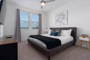 a bedroom with a bed and a desk and windows at 2 King Suites, Pool Near Oak Mountain in Acton +78 photos