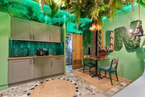 a kitchen with green walls and a table and chairs at Jungle & Sauna in Chaville