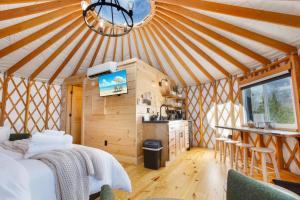 a room with a bed and a kitchen in a yurt at Horizon Hideout - Modern Yurt in Brookville