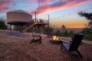 a group of benches sitting around a fire pit at Horizon Hideout - Modern Yurt in Brookville +16 photos