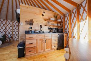 a kitchen in a yurt with a sink and wooden cabinets at Horizon Hideout - Modern Yurt in Brookville