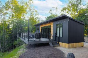een tiny house met een groot terras in het bos bij Twilight Haven - Hot Tub in Shippenville +8 foto's