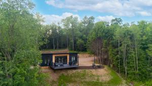 een huis met een groen dak in het bos bij Twilight Haven - Hot Tub in Shippenville