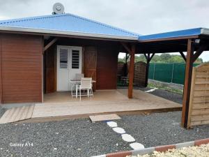 einen Pavillon mit einem Tisch und Stühlen auf einer Holzterrasse in der Unterkunft Maison charmante à Sainte-Anne, 20 m², jardin tranquille in Boivin
