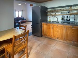 a kitchen with a black refrigerator and a table at Casa Cachalote - Ferienhaus auf den Azoren in São Caetano +13 photos
