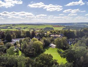 eine Luftansicht auf ein Dorf mit Bäumen und Häusern in der Unterkunft The Old Rectory Cottages - Six Luxurious Cottages Set In Grounds With Indoor Pool in Kings Nympton