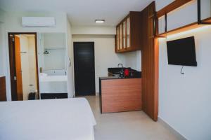 a room with a bedroom with a bed and a tv at Loft completo e climatizado a 2 minutos do centro in Cuiabá