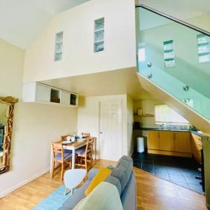 ein Wohnzimmer mit einem blauen Sofa und einer Treppe in der Unterkunft Bramble Cottage in Saint Columb Minor