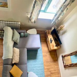 ein Wohnzimmer mit einem grauen Sofa und einem Fenster in der Unterkunft Bramble Cottage in Saint Columb Minor